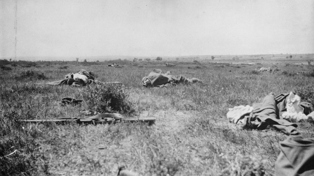 The scene after an attack by the 2nd Infantry Brigade. Several bodies are lying on the ground and a rifle is in the left foreground.